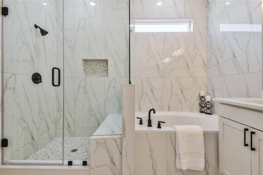 Large step-in frameless shower with pebble floor and built in seat.