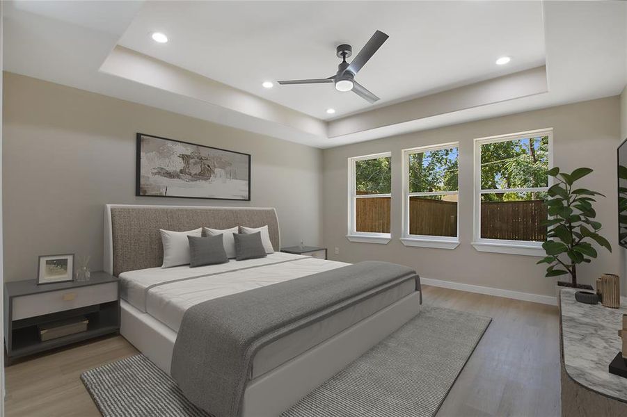 Bedroom featuring a tray ceiling, ceiling fan, and light hardwood / wood-style flooring