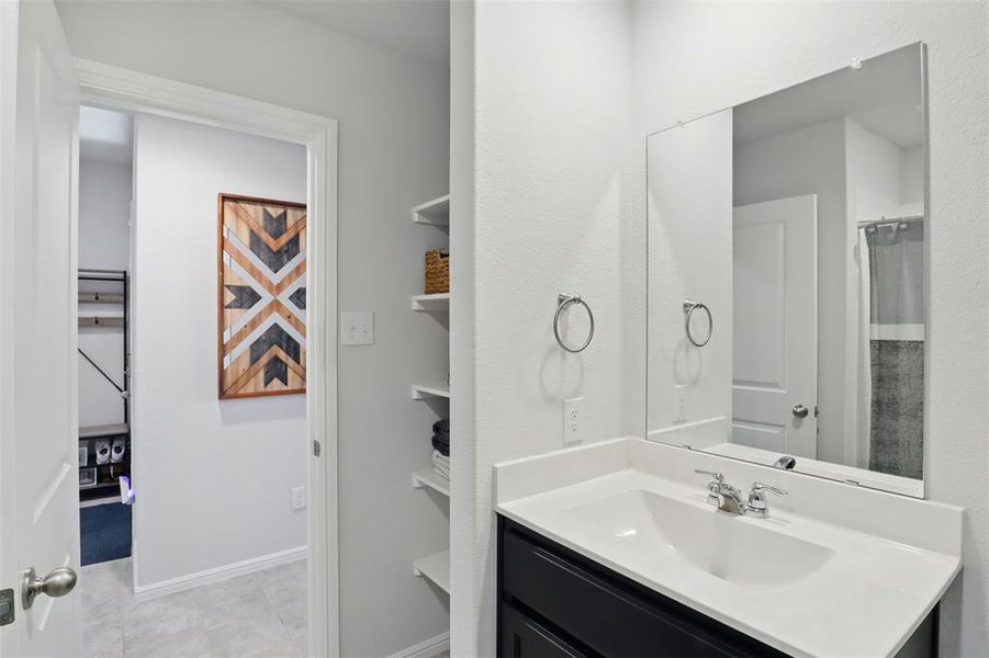 Full bath featuring tile patterned floors, baseboards, and vanity