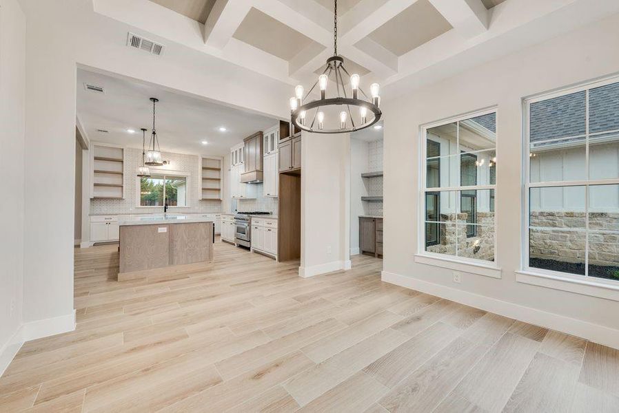 Kitchen featuring light hardwood / wood-style flooring, high end stainless steel range, pendant lighting, and a center island