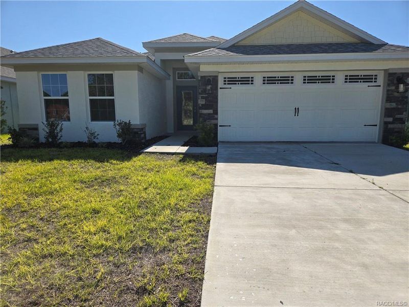 Front exterior of a new home in Wyld Palms, Inverness, FL, highlighting curb appeal (Image 1).