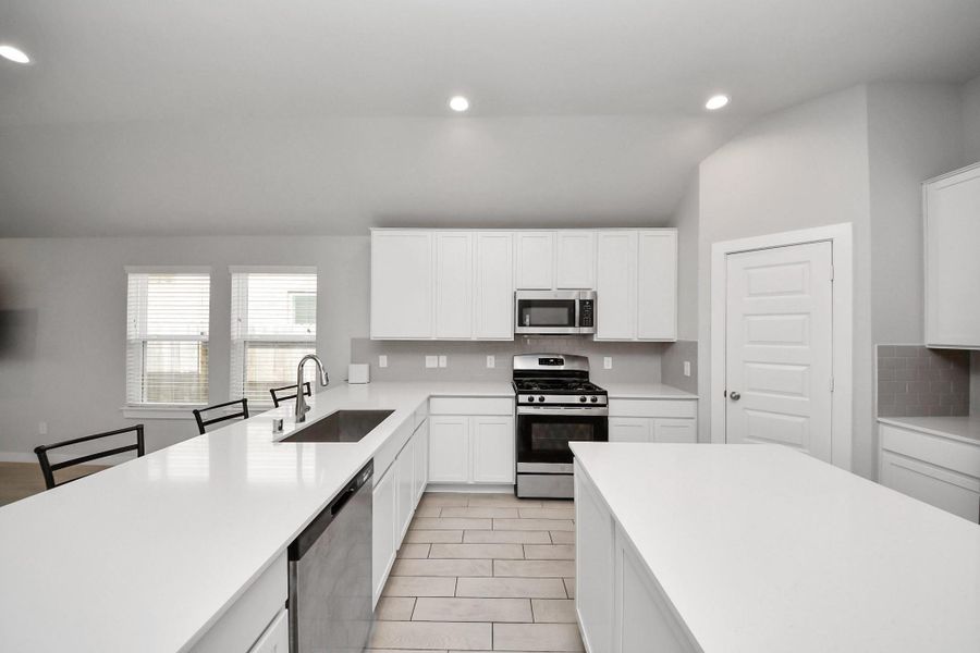 Spacious kitchen offering an abundance of counter space, a large island, and a sink that faces the main living areas—perfect for staying connected while cooking or entertaining.