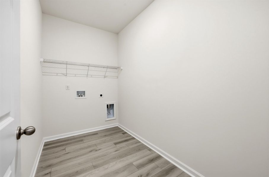 Laundry room with light wood-type flooring, hookup for an electric dryer, and washer hookup