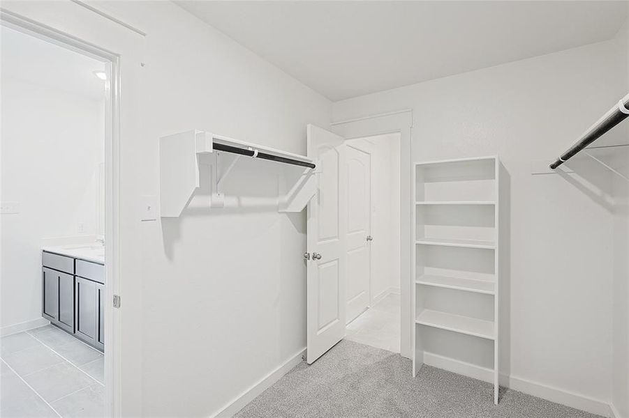 Spacious closet with light tile patterned floors