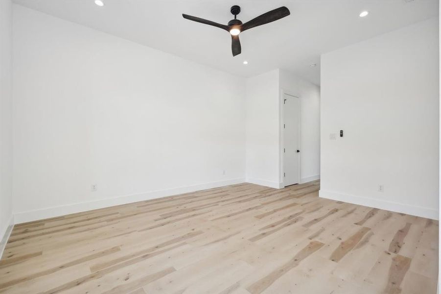 Empty room with light hardwood / wood-style flooring and ceiling fan