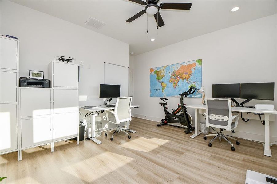 This secondary bedroom upstairs has nice windows with ample natural light highlighting the wood flooring.