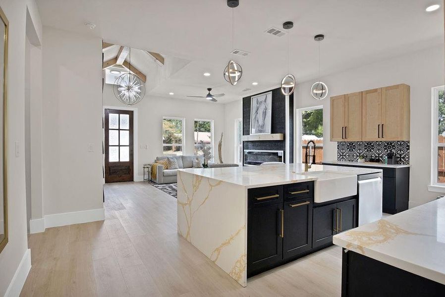 Kitchen with a center island with sink, light brown cabinetry, light hardwood / wood-style floors, sink, and ceiling fan