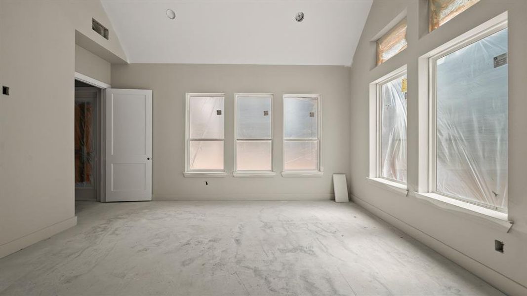 Primary bedroom with cathedral ceilings.