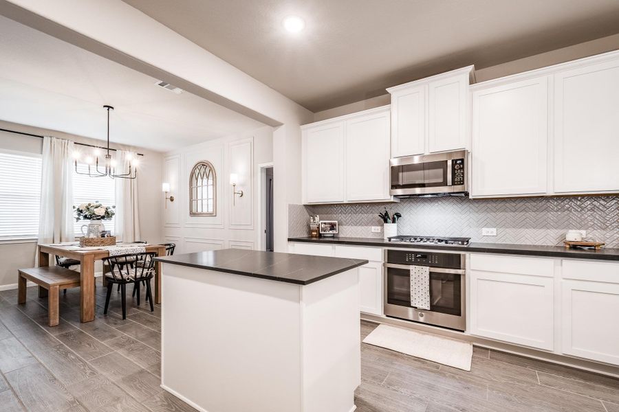 This modern kitchen features sleek white cabinetry, stainless steel appliances, and a stylish herringbone backsplash. An open layout connects to a cozy dining area with a wooden table and bench seating, perfect for family gatherings. The space is bright and inviting, with ample natural light and elegant fixtures. This modern kitchen features sleek white cabinetry, stainless steel appliances, and a stylish herringbone backsplash. An open layout connects to a cozy dining area with a wooden table and bench seating, perfect for family gatherings. The space is bright and inviting, with ample natural light and elegant fixtures.