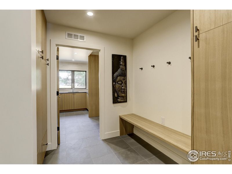 Expansive mud room leading to the laundry room with custom cabinetry