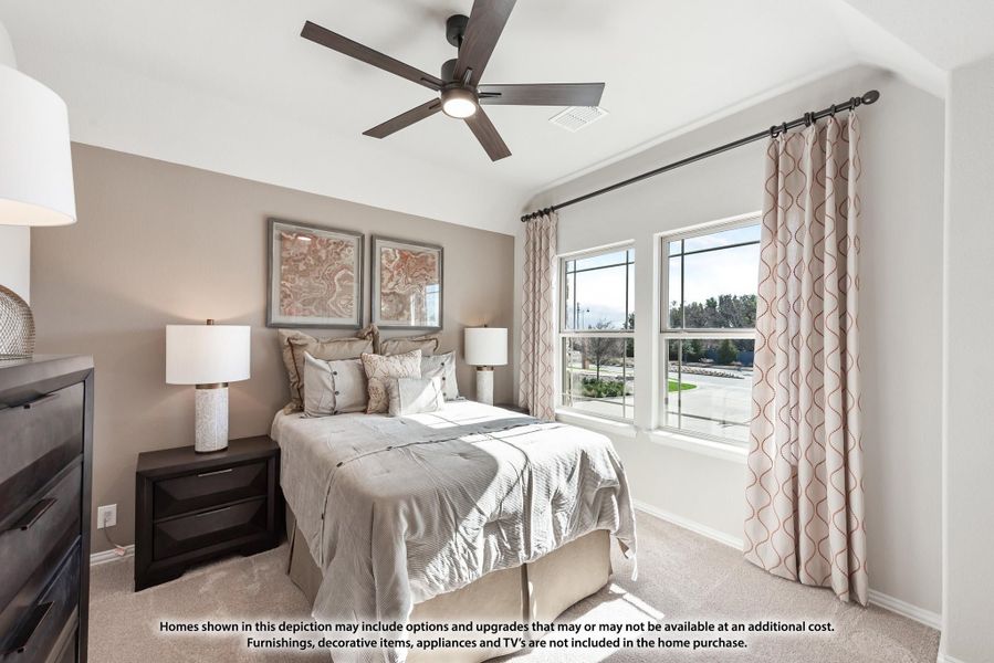 Bedroom with ceiling fan, carpet flooring, two windows with curtains, and framed wall art above the bed