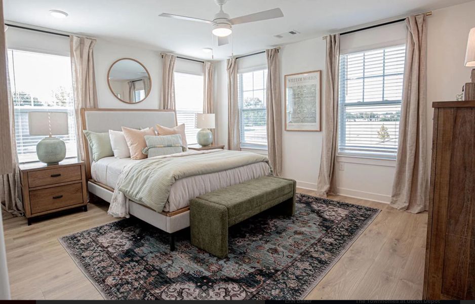 Bedroom featuring multiple windows, light wood finished floors, and ceiling fan
