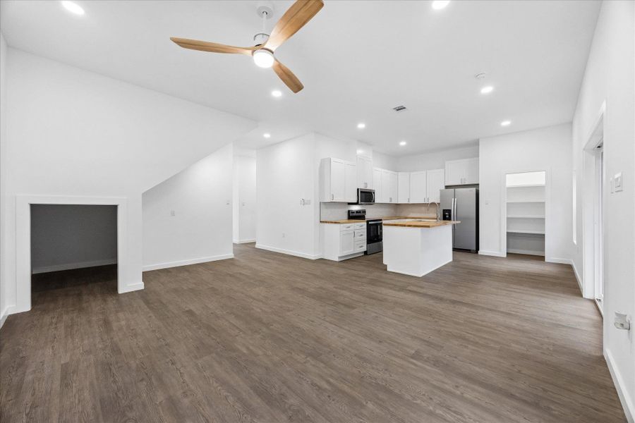 An open-concept living space integrates a well-appointed kitchen with hardwood-style flooring throughout.