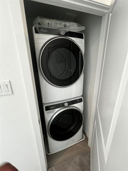 Dedicated laundry closet featuring a stacked washer and dryer unit Dedicated laundry closet featuring a stacked washer and dryer unit