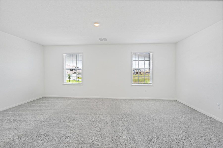A quiet retreat, this spacious room features plush carpeting and abundant natural light from multiple windows.
