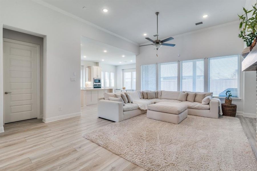 Living area featuring recessed lighting, light wood-style flooring, visible vents, and ceiling fan Living area featuring recessed lighting, light wood-style flooring, visible vents, and ceiling fan