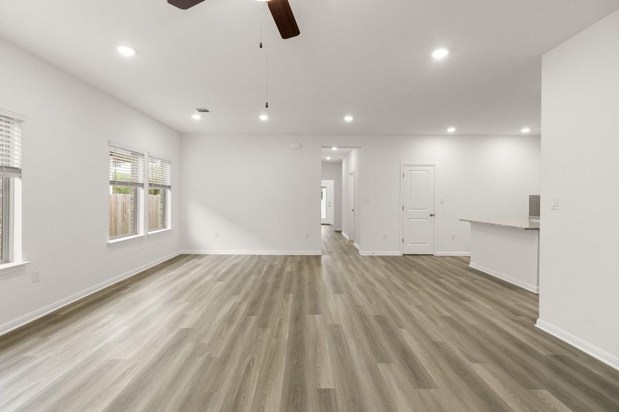 Spacious interior with light-toned hardwood style flooring, recessed lighting, and a ceiling fan