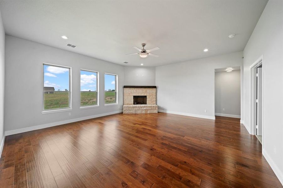 Unfurnished living room with dark hardwood / wood-style flooring and ceiling fan