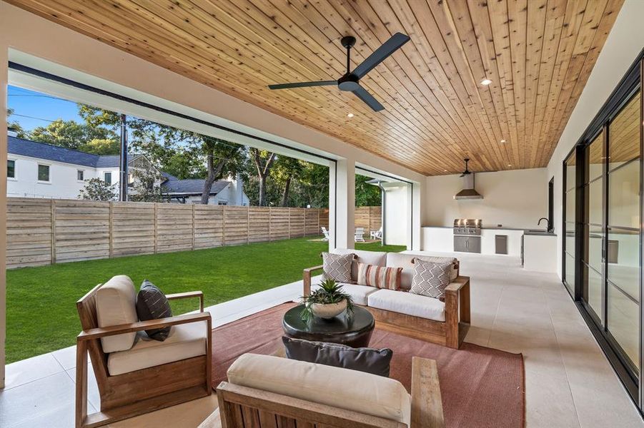 Expansive outdoor living space with motorized screens, Coyote grill, vent hood, and refrigerator and Scotsman Icemaker with prep sink.