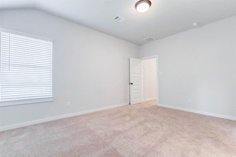 This upstairs secondary bedroom offers a peaceful retreat with plush carpet, soft neutral tones, and a large window bringing in natural light. Whether used as a guest suite, office, or kid’s room, the space is versatile and move-in ready.