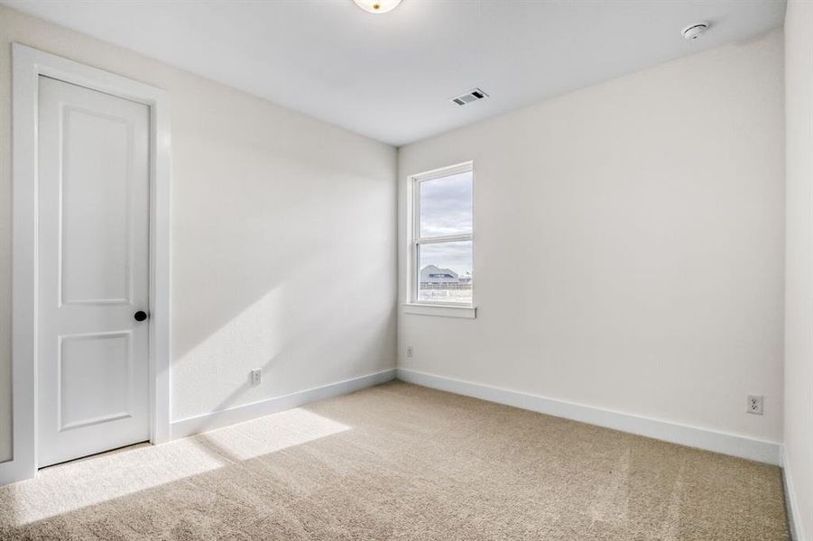 Carpeted spare room featuring baseboards