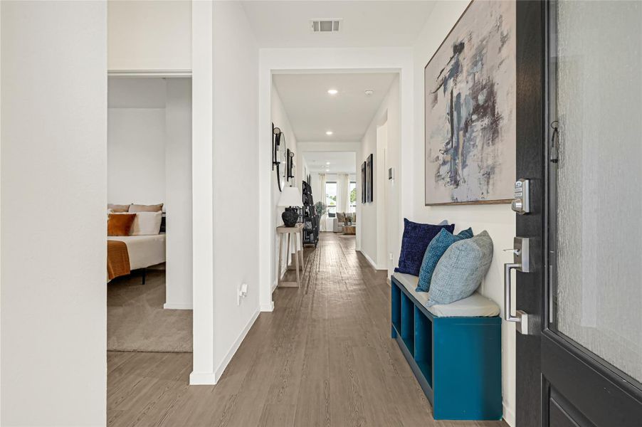 Inviting entryway with modern decor and a cozy bench leads to an open and bright living area, featuring sleek hardwood floors and stylish artwork. Inviting entryway with modern decor and a cozy bench leads to an open and bright living area, featuring sleek hardwood floors and stylish artwork.