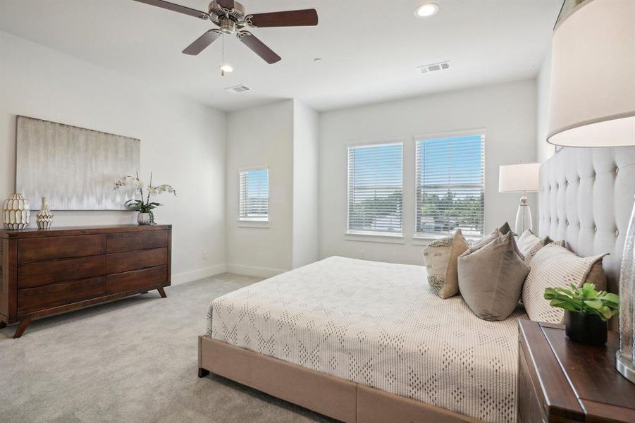 Bedroom with ceiling fan and light colored carpet