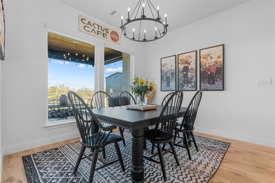 Dining area with hardwood / wood-style floors and a notable chandelier