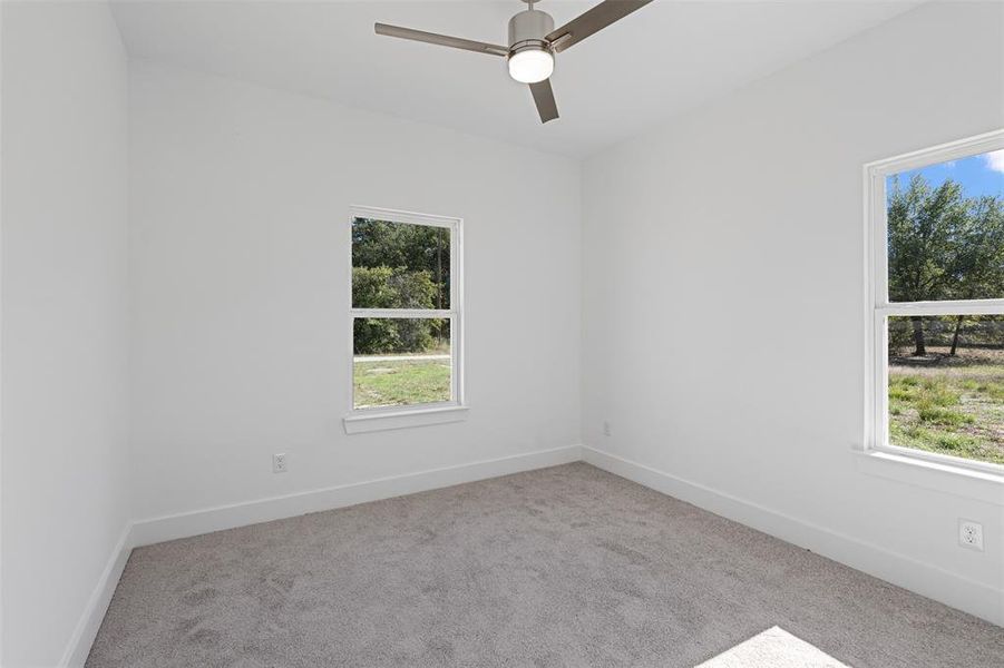 Spare room featuring light colored carpet and ceiling fan