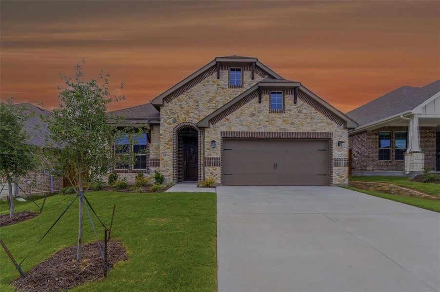 Stone and brick veneer exterior featuring a dark wood front door, an arched entry, and a two-car garage