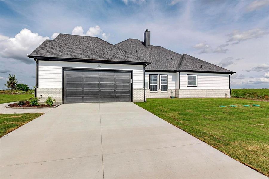 View of front of home with a garage and a front yard