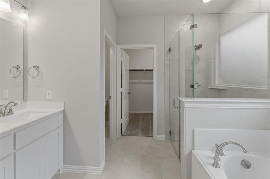 Contemporary bathroom featuring dual vanities with integrated sinks, a glass-enclosed shower with tiled walls, a built-in soaking tub, and neutral-toned floor tiling