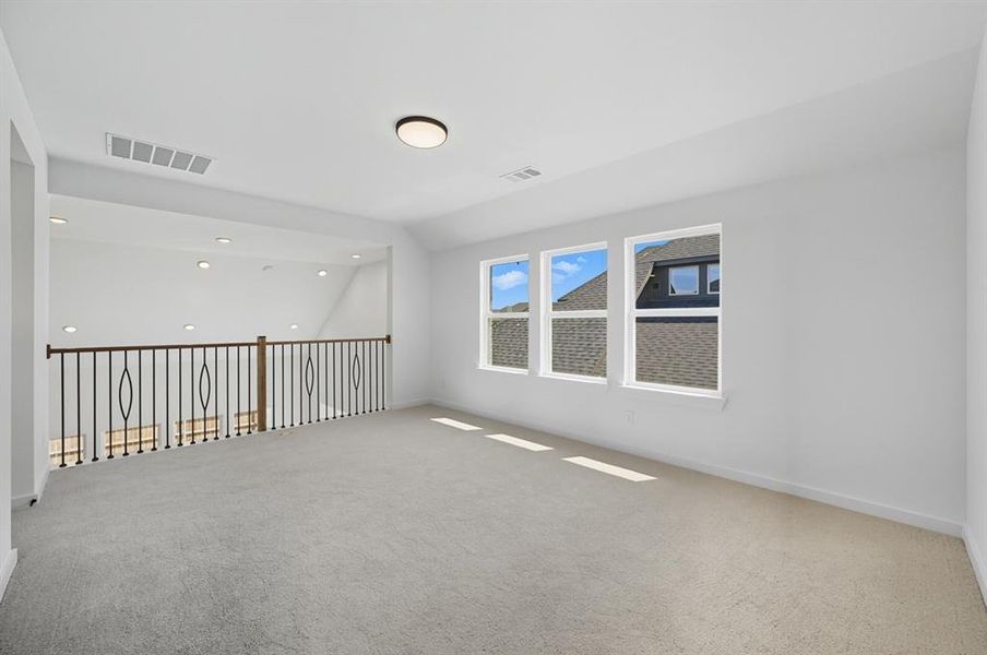 Carpeted spare room with lofted ceiling and recessed lighting Carpeted spare room with lofted ceiling and recessed lighting