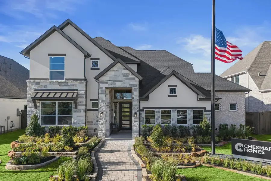 Front exterior of a new home in Riceland 60',65',70', Mont Belvieu, TX, highlighting curb appeal (Image 1). Front exterior of a new home in Riceland 60',65',70', Mont Belvieu, TX, highlighting curb appeal (Image 1).