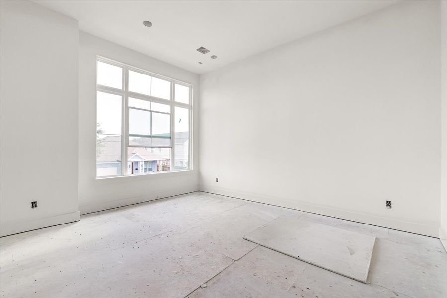 Primary bedroom with large windows.