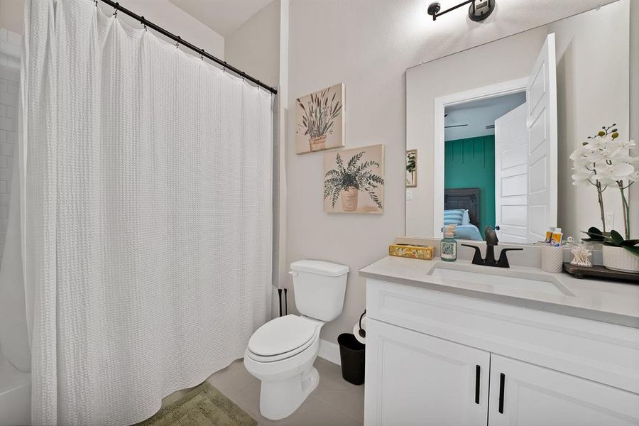 Full bathroom featuring a white vanity with integrated sink, matte black faucet, and a large wall-mounted mirror Full bathroom featuring a white vanity with integrated sink, matte black faucet, and a large wall-mounted mirror