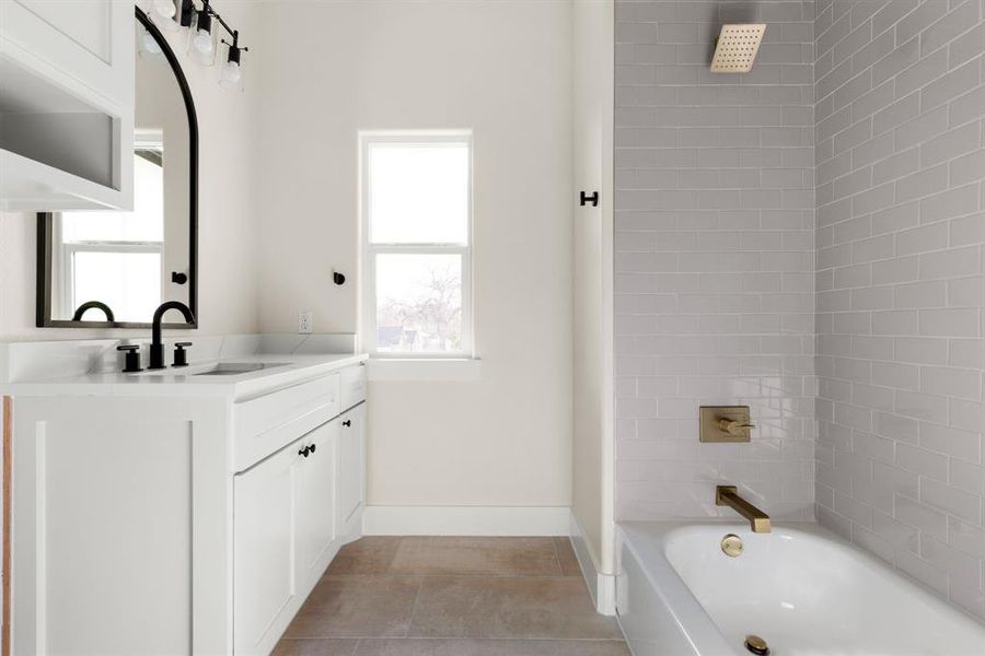 Bathroom featuring tile patterned flooring, vanity, and tiled shower / bath combo