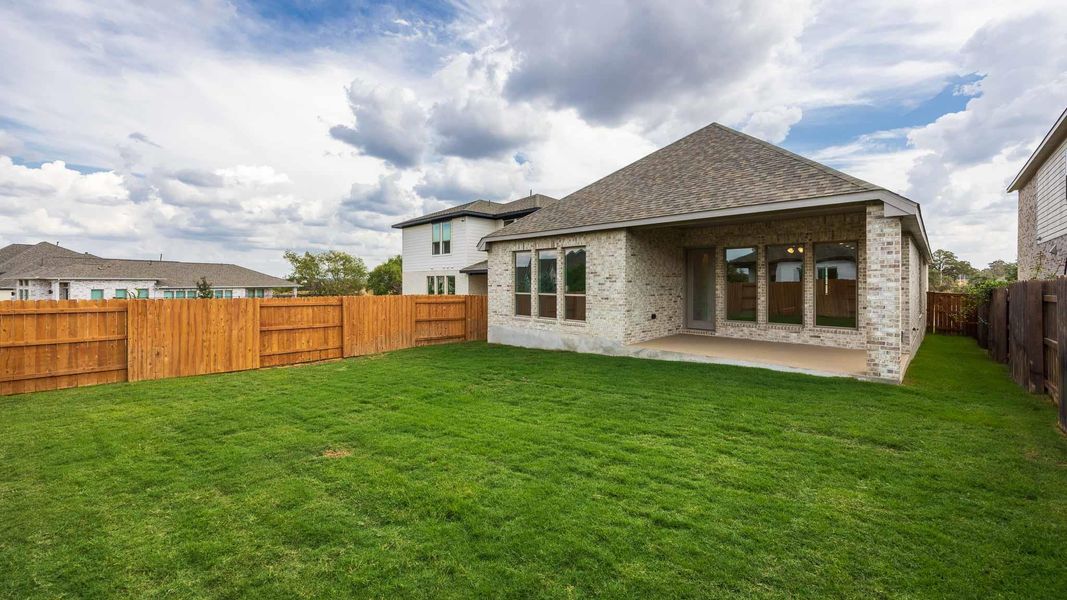 Rear view of property with a fenced backyard, brick siding, a patio area, and roof with shingles Rear view of property with a fenced backyard, brick siding, a patio area, and roof with shingles