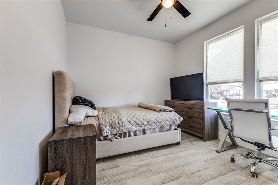 Bedroom with a ceiling fan and light wood-style floors