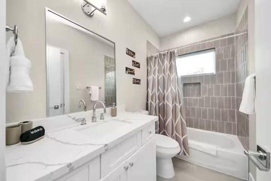 A full secondary bath with vanity storage and a tiled tub/shower combination keeps the upstairs layout practical for guests or additional occupants.