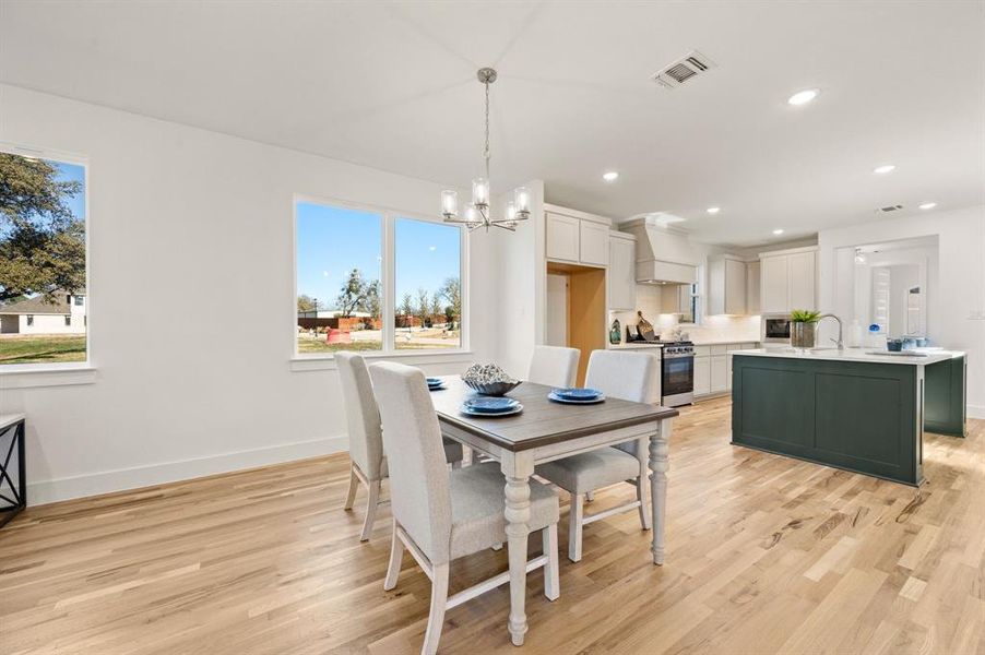 Dining area featuring light wood finished floors and a chandelier