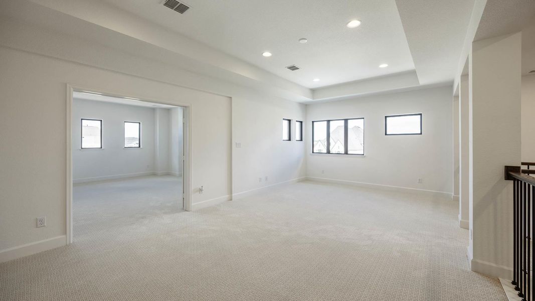 Unfurnished bedroom with light colored carpet, a tray ceiling, multiple windows, and recessed lighting Unfurnished bedroom with light colored carpet, a tray ceiling, multiple windows, and recessed lighting