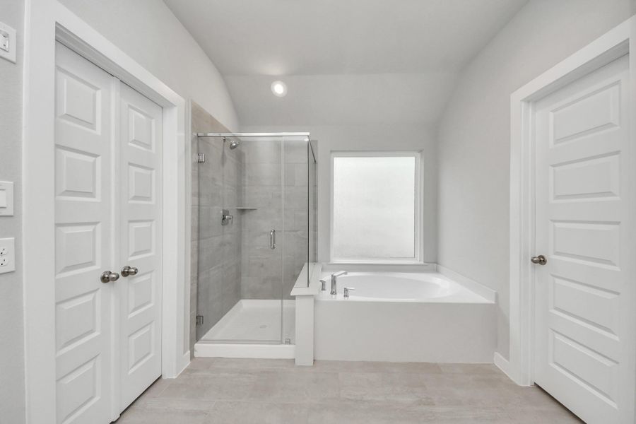 Elevate your daily routine at the elegant vanity, now equipped with double sinks, light countertops, modern hardware, and beautiful recessed lights.