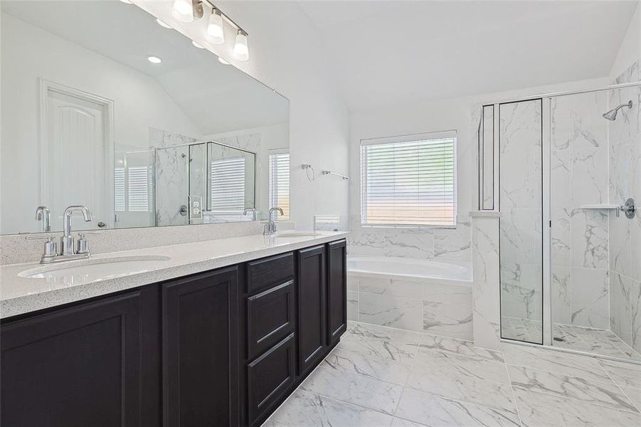 Bathroom with plus walk in shower, vaulted ceiling, and vanity