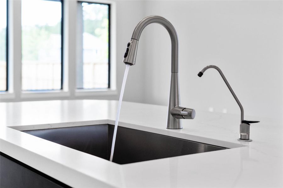 The modern undermount sink is perfectly in the kitchen island, offering views the open-concept living space.
