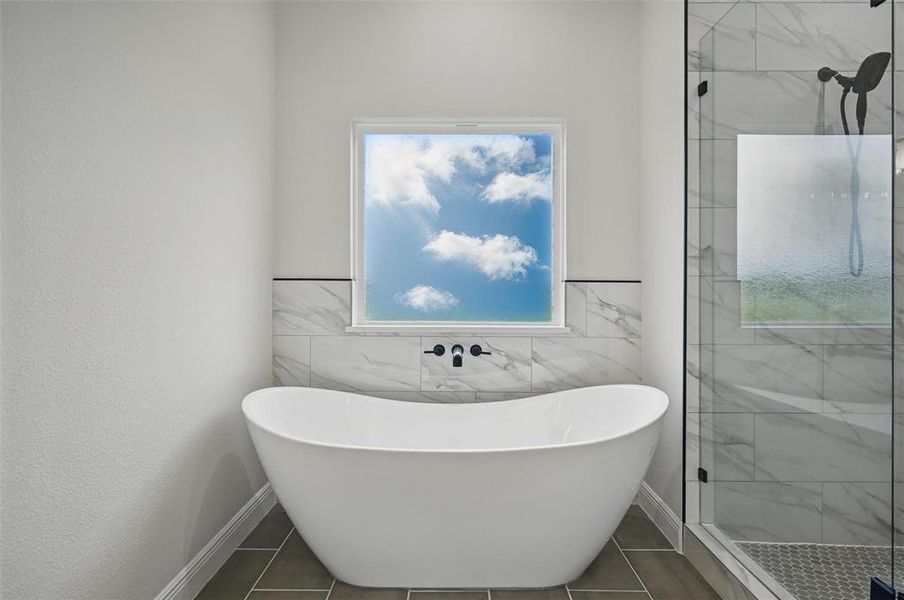 Full bathroom featuring a freestanding tub, a shower stall, tile patterned flooring, and tile walls Full bathroom featuring a freestanding tub, a shower stall, tile patterned flooring, and tile walls