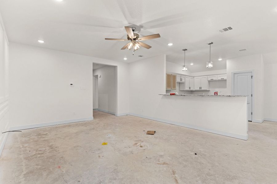 Unfurnished living room with a ceiling fan, concrete flooring, and recessed lighting Unfurnished living room with a ceiling fan, concrete flooring, and recessed lighting