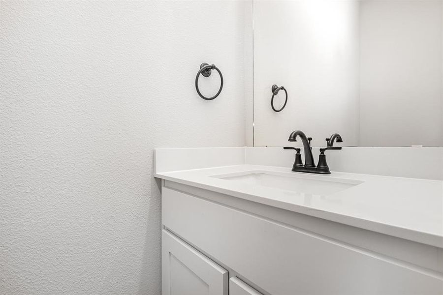 Bathroom with vanity and a textured wall