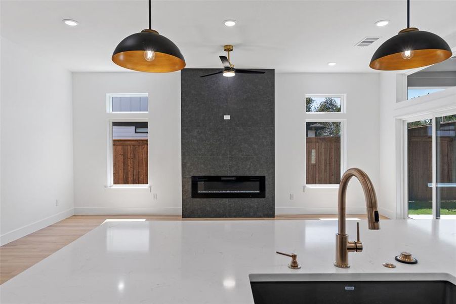 Kitchen with light wood-type flooring, hanging light fixtures, sink, and ceiling fan