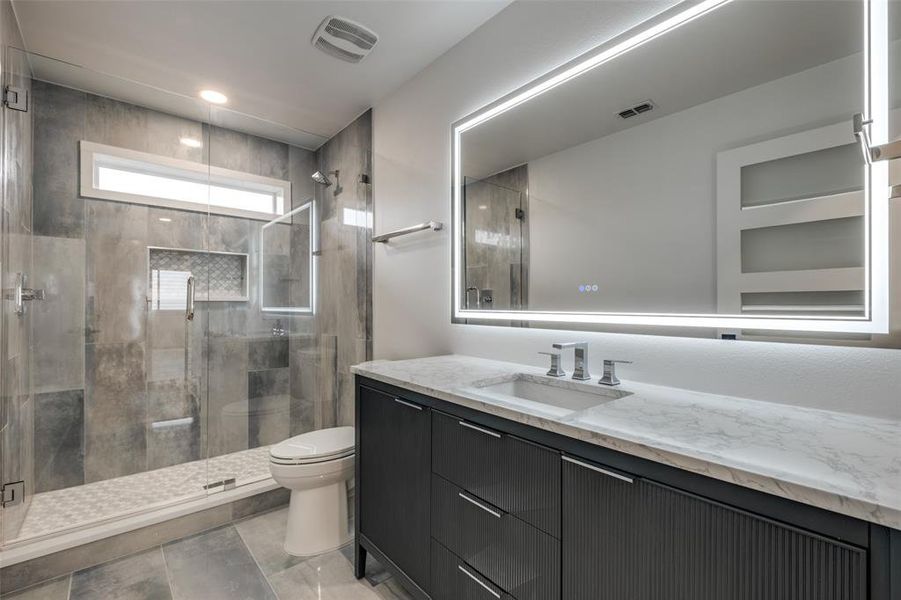 Bathroom featuring a stall shower and vanity